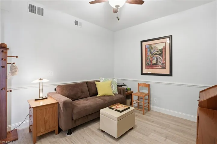 Den with LVP flooring, desk and ceiling fan