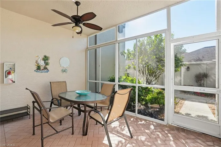 Sunroom featuring a ceiling fan and outdoor dining furniture