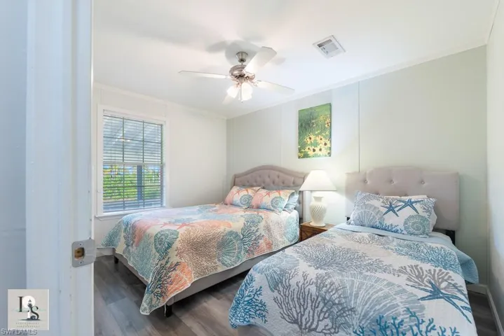 Bedroom with crown molding, wood finished floors, and a ceiling fan