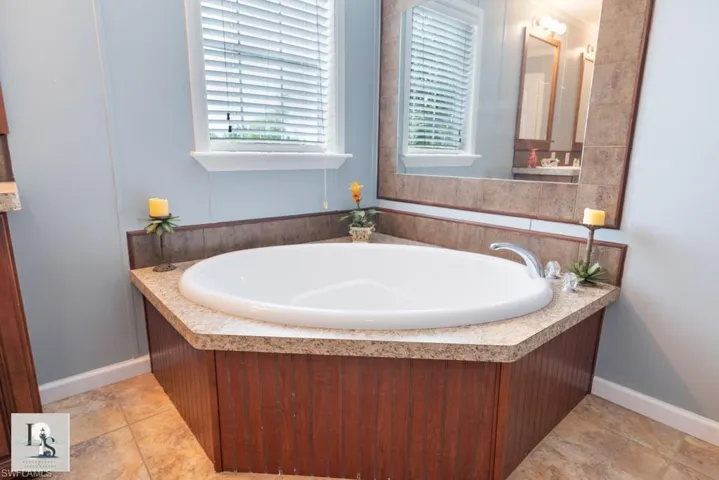 Bathroom with a garden tub and baseboards