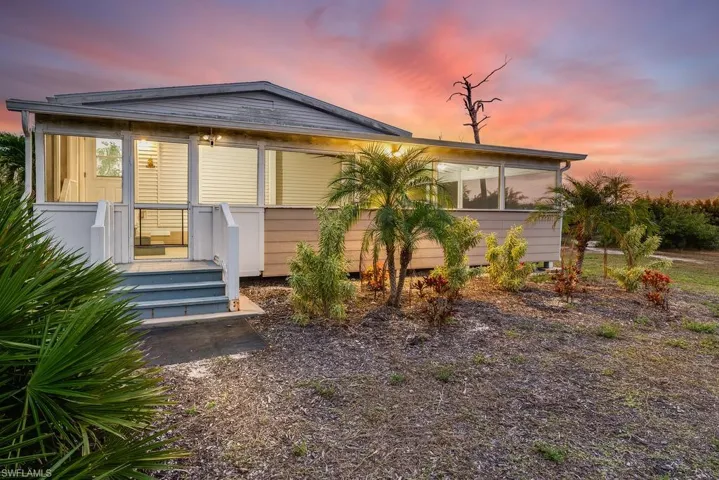 Rear view of property with a sunroom