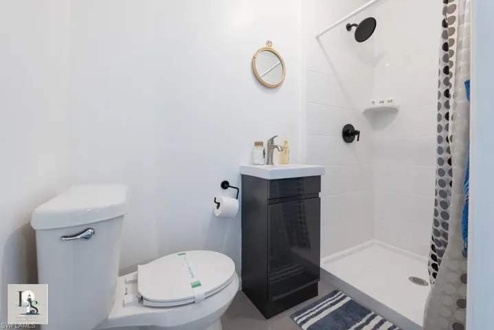 Full bath featuring a stall shower, vanity, and tile patterned flooring