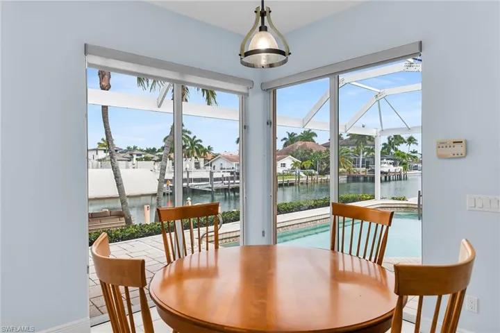 Dining area featuring plenty of natural light, a water view, and a sunroom