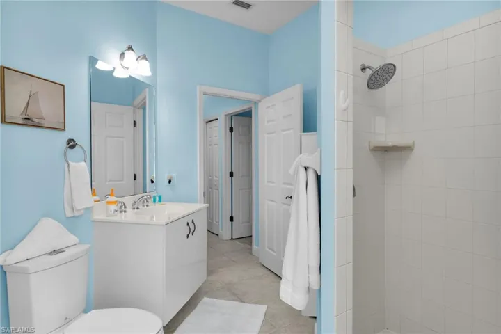 Bathroom featuring vanity, a tile shower, and light tile patterned floors