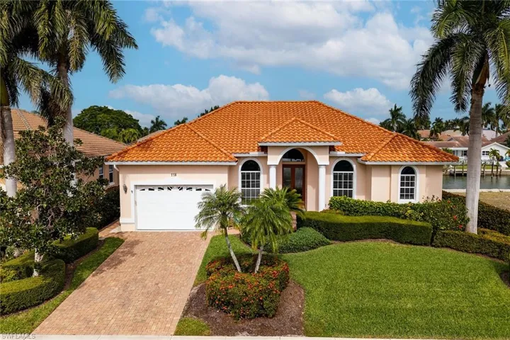 Mediterranean / spanish home with stucco siding, an attached garage, decorative driveway, and a tiled roof