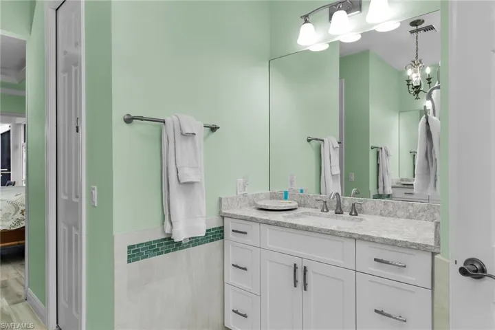 Ensuite bathroom featuring vanity and a chandelier