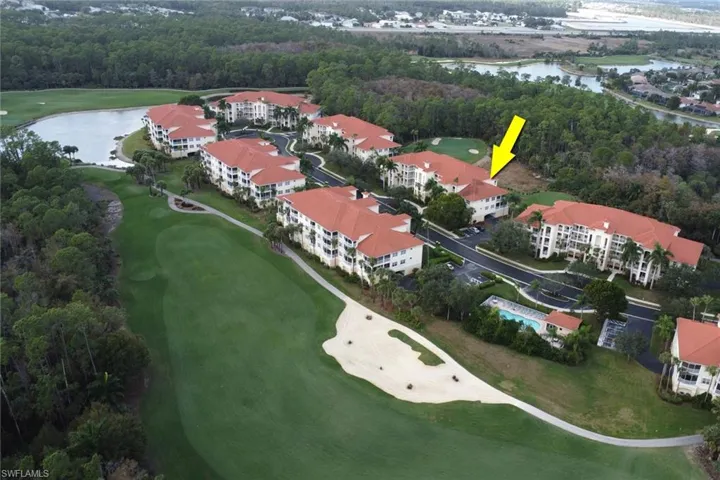Drone / aerial view of a large body of water and apartment complex / building