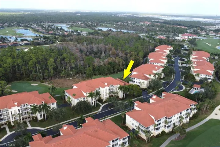 Drone / aerial view of a local golf course and a nearby body of water