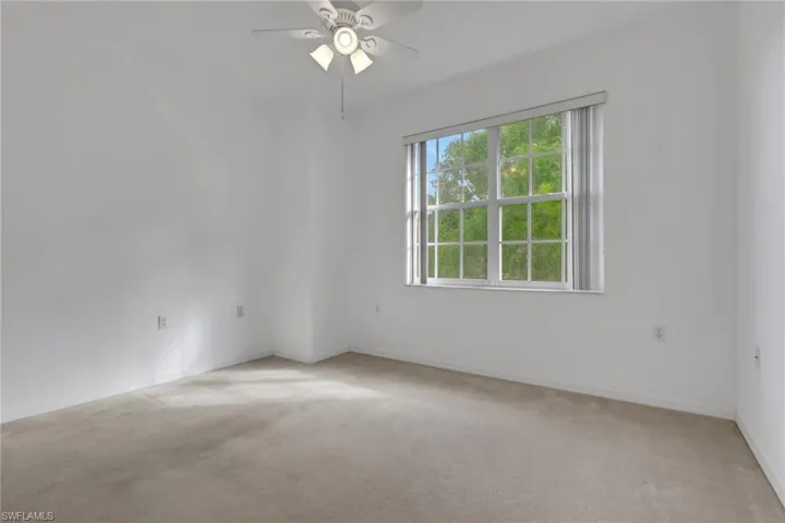 Unfurnished room with light colored carpet and ceiling fan
