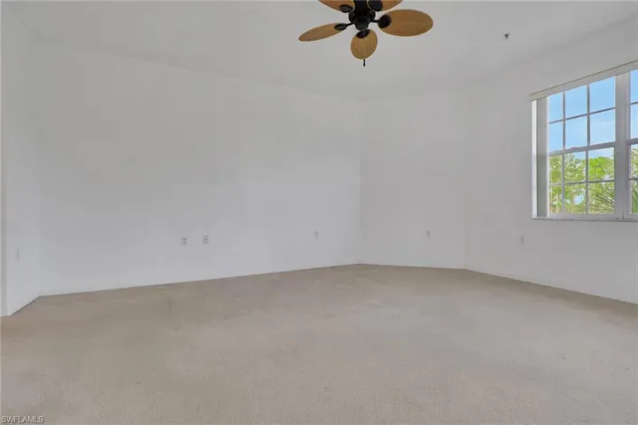Unfurnished room with ceiling fan and light colored carpet