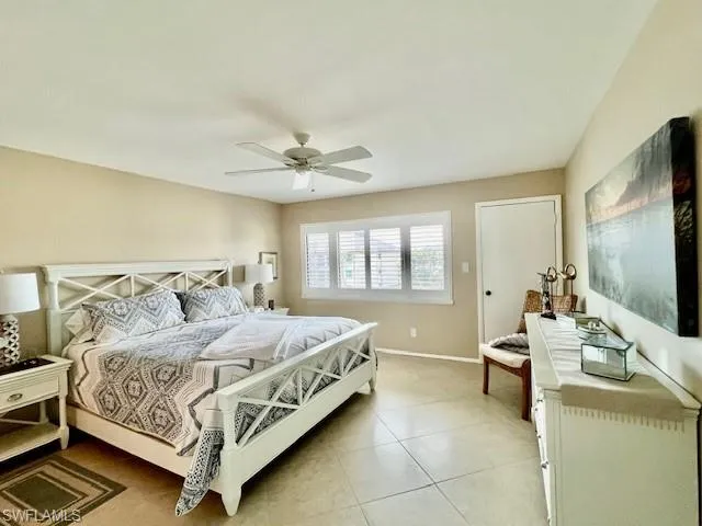 Bedroom with ceiling fan and light tile patterned flooring