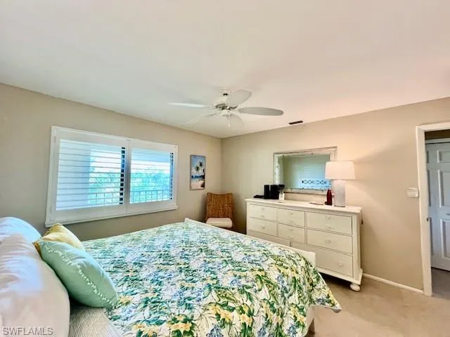 Carpeted bedroom featuring ceiling fan