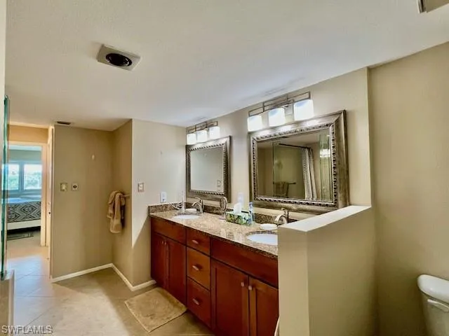 Bathroom with vanity, toilet, and a textured ceiling