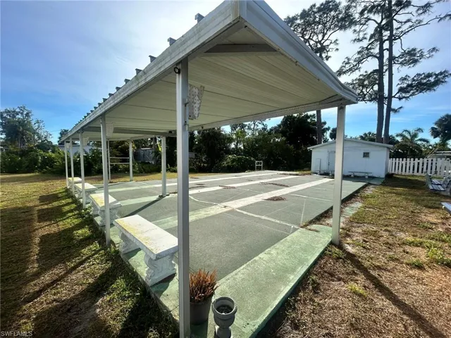 View of home's community with fence and shuffleboard