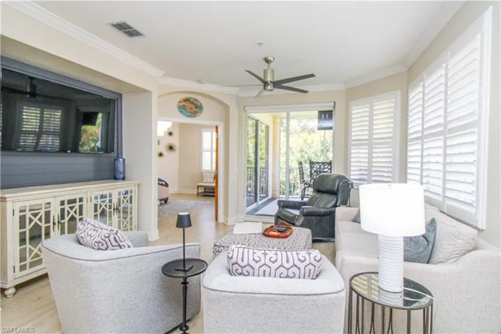 Living room featuring light hardwood / wood-style floors, crown molding, and ceiling fan