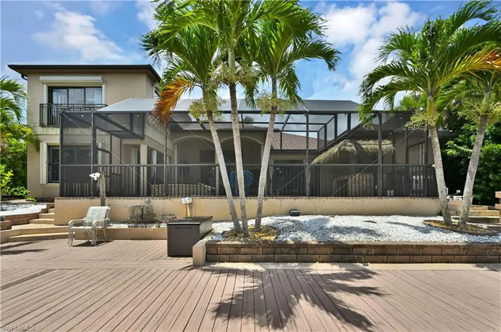 Expansive wood-finish deck with mature palm trees