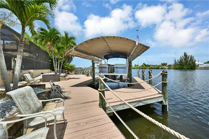 Waterfront dock with a covered boat lift, featuring robust pilings and rope accents