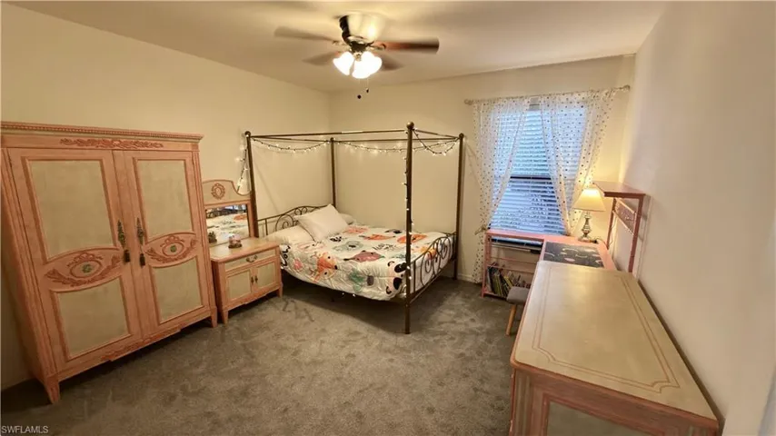 Bedroom with dark carpet and ceiling fan