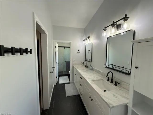 Bathroom with double vanity and a stall shower