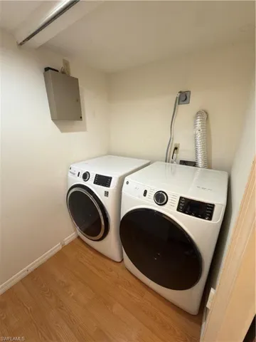 Laundry area featuring washer and clothes dryer and light wood-type flooring