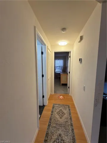 Corridor with light wood-style flooring