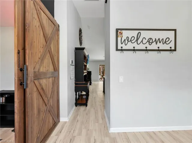 Hall featuring a barn door and light wood-type flooring