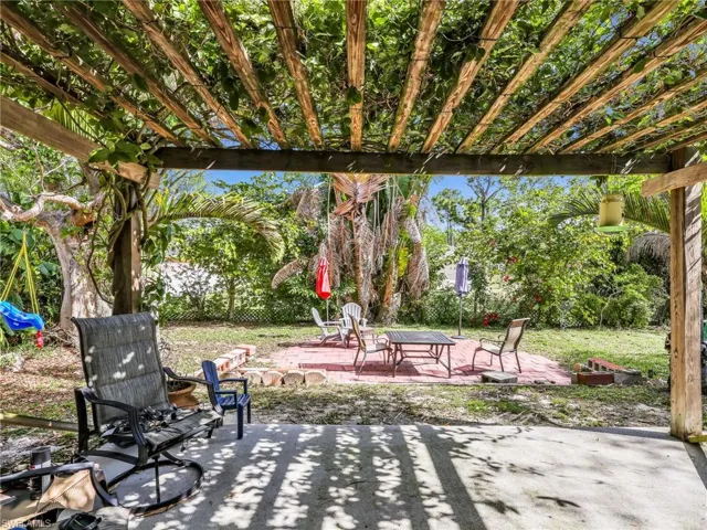 View of patio with an outdoor fire pit and a pergola