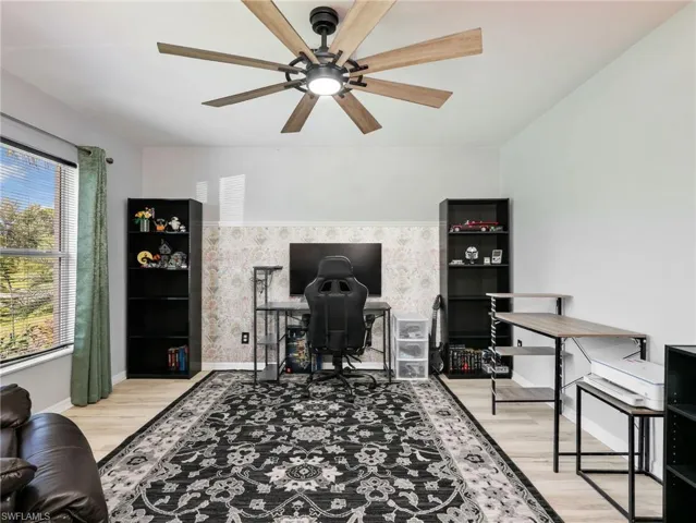 Office area featuring light wood-style flooring and a ceiling fan