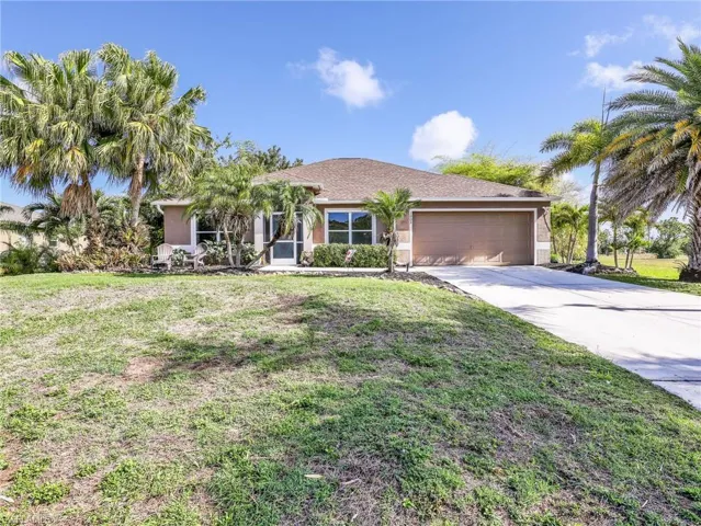 Single story home with an attached garage, a front yard, and driveway