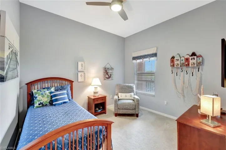 Carpeted bedroom featuring ceiling fan