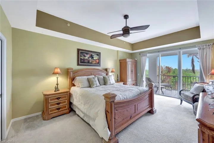 Carpeted bedroom with access to outside and ceiling fan