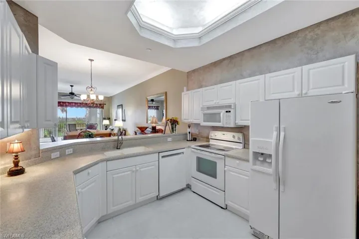 Kitchen with white appliances, white cabinetry, sink, and ornamental molding