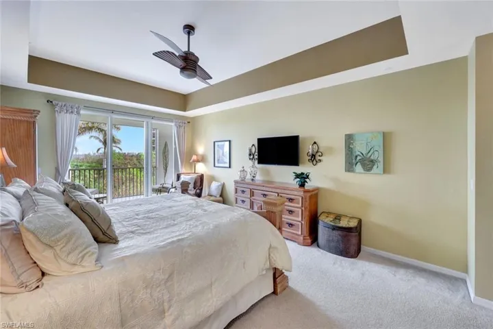 Carpeted bedroom featuring ceiling fan and access to outside
