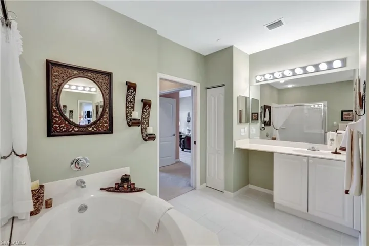 Bathroom featuring vanity, tile patterned floors, and separate shower and tub