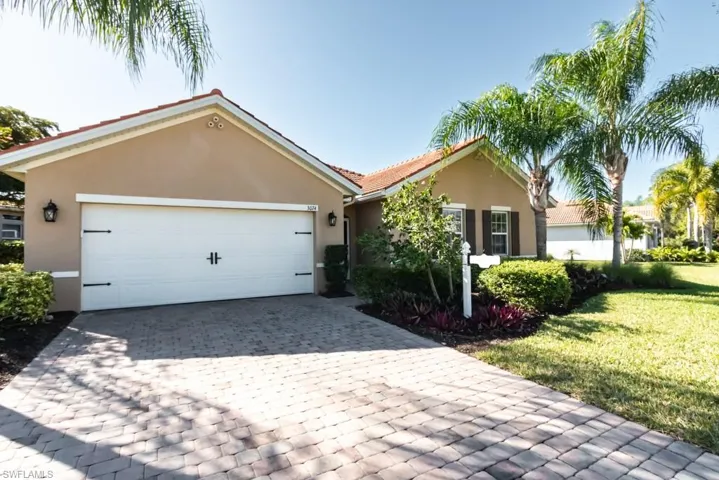 Ranch-style home featuring a garage and a front yard