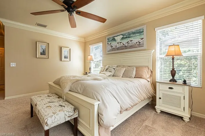 Carpeted bedroom with ornamental molding and ceiling fan