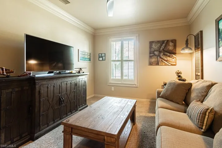 Living room featuring ornamental molding and carpet floors