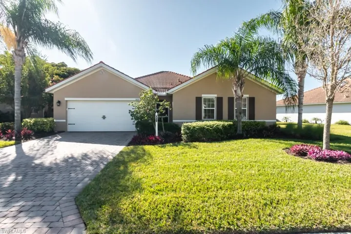 Ranch-style home featuring a garage and a front lawn