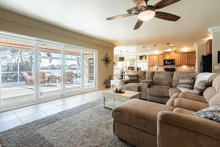 Tiled living room with crown molding and ceiling fan