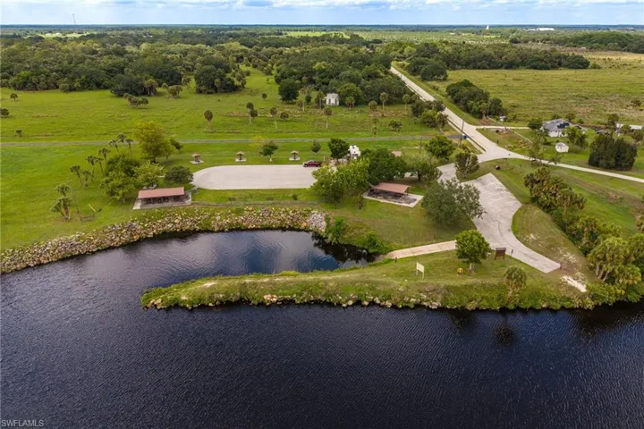 Expansive waterfront property featuring a paved boat ramp, substantial rock revetment, and a covered picnic area