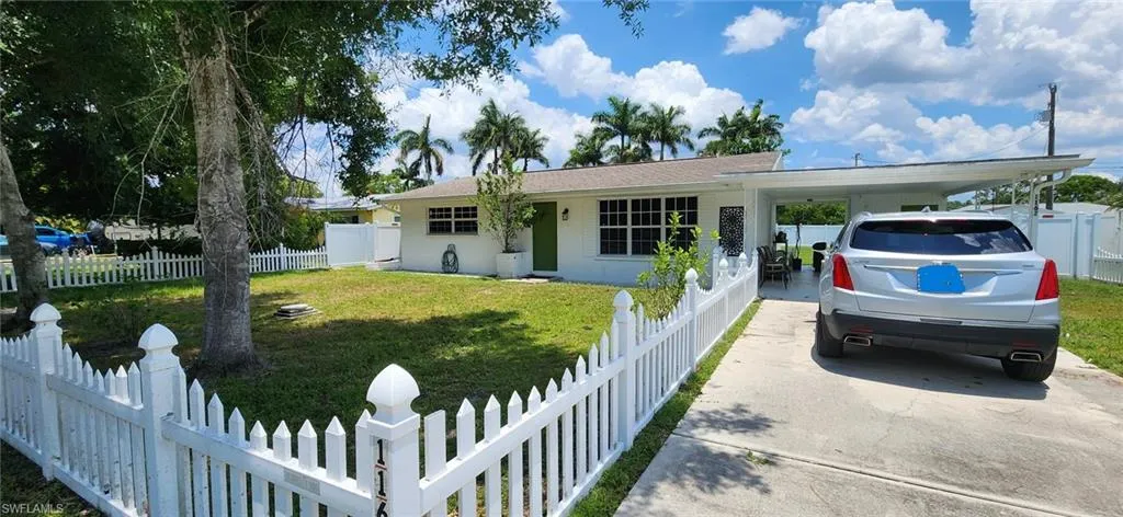 View of front of home featuring a front yard and a carport