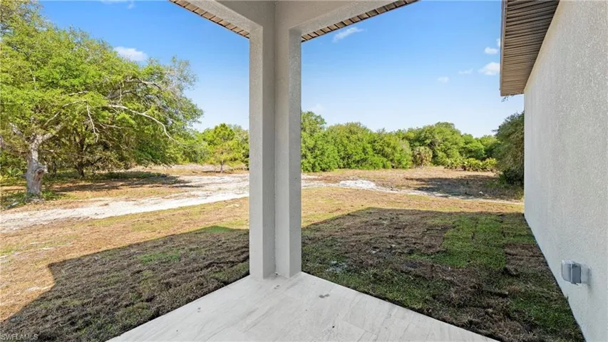 View of grassy yard featuring a patio