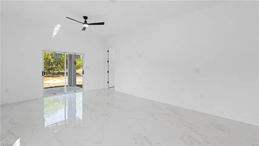 Empty room featuring ceiling fan and light marble finish flooring