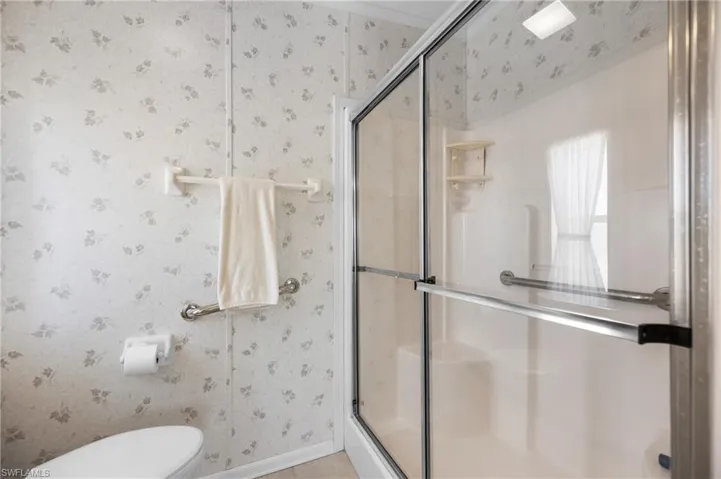 Walk-in shower with clear glass enclosure and chrome hardware