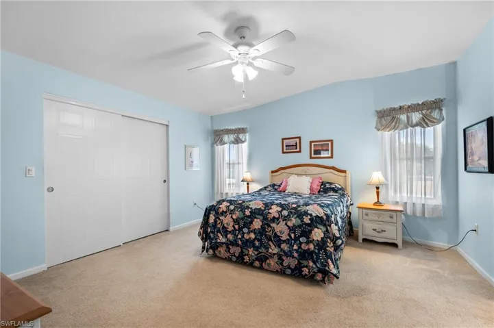 Carpeted room featuring a vaulted ceiling and a ceiling fan with light fixture
