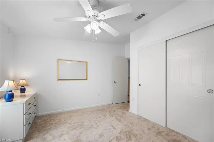 Bedroom with neutral carpet flooring and white walls