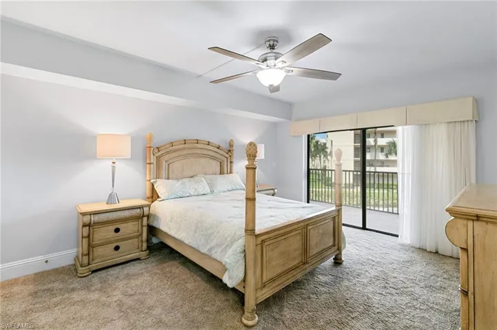 Carpeted bedroom with access to outside and ceiling fan
