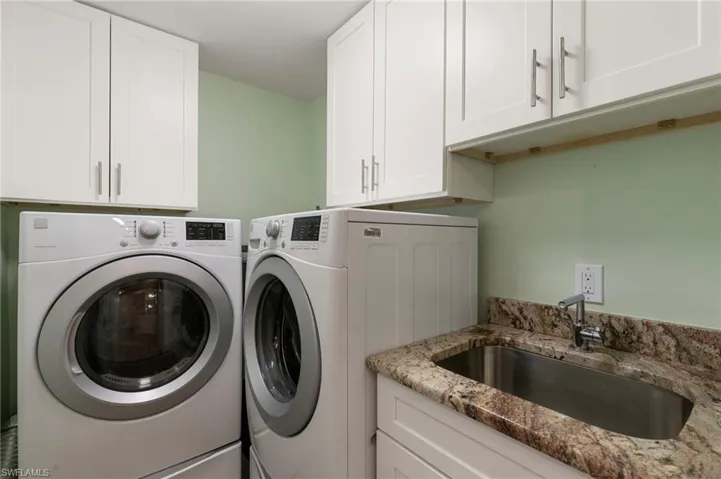 Washroom with a sink and washing machine and dryer