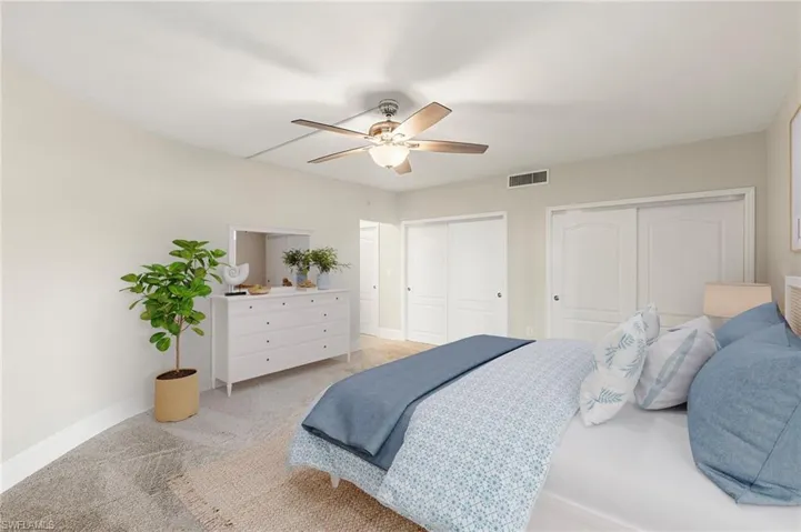 STAGED: Bedroom with two closets, ceiling fan, and carpet flooring