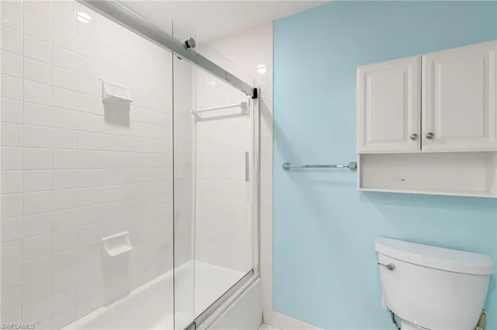 Bathroom with tiled shower / bath and toilet